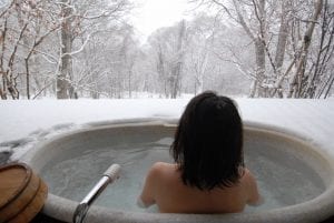 woman in open air bath while snowing