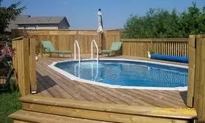 An above ground pool, built in the backyard surrounded by a fenced deck, from Splashworks Pool and Spa.